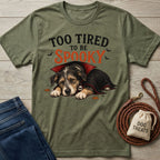 Olive green crewneck t-shirt featuring a sleepy dog in a vampire cape with the text Too Tired To Be Spooky.