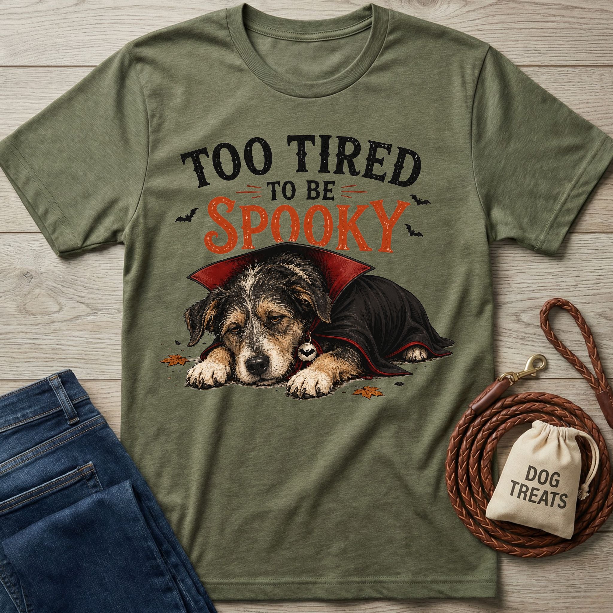 Olive green crewneck t-shirt featuring a sleepy dog in a vampire cape with the text Too Tired To Be Spooky.