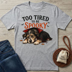 Grey crewneck t-shirt featuring a sleepy puppy in a vampire cape with the text Too Tired To Be Spooky.