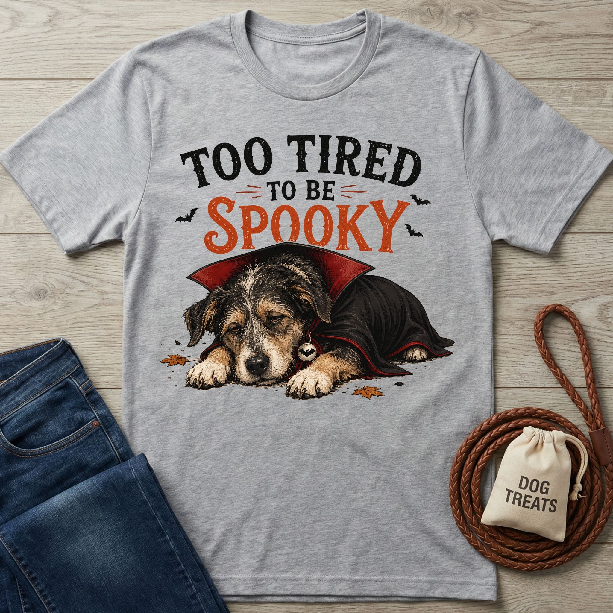 Grey crewneck t-shirt featuring a sleepy puppy in a vampire cape with the text Too Tired To Be Spooky.