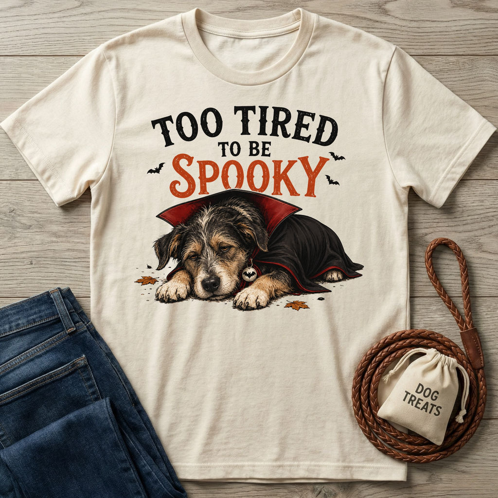 Cream-colored crewneck t-shirt featuring a sleepy puppy in a vampire cape with the text Too Tired To Be Spooky.