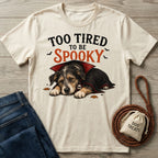 Cream-colored crewneck t-shirt featuring a sleepy puppy in a vampire cape with the text Too Tired To Be Spooky.