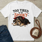 White crew neck t-shirt featuring a sleeping puppy in a vampire cape with the text Too Tired To Be Spooky.