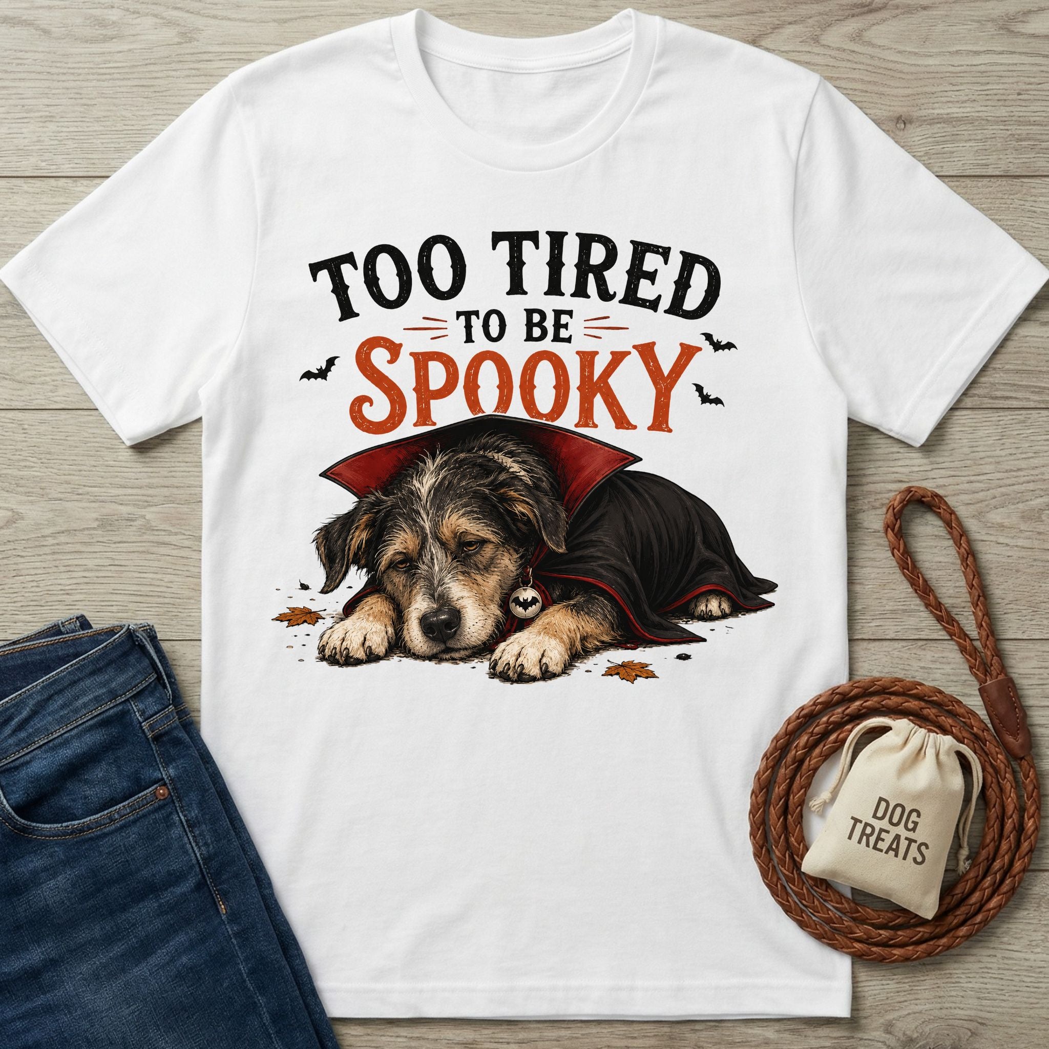 White crew neck t-shirt featuring a sleeping puppy in a vampire cape with the text Too Tired To Be Spooky.