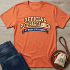 Orange Gildan Softstyle® t-shirt with "Official Poop Bag Carrier" text, next to jeans and dog treats.