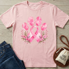 Light pink T-shirt featuring a watercolor breast cancer ribbon paw print design with delicate floral accents.