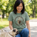 Woman in an sage green "Powered By Caffeine & Rescue Dogs" t-shirt with a pug.
