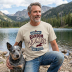 Man wearing a beige crewneck t-shirt with a vintage-style Random Zoomies graphic, posing outdoors with a blue heeler dog.