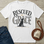 White crewneck t-shirt featuring a black dog illustration and Rescued By Grace typography in black and gold.