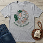 Light grey Gildan Softstyle® t-shirt with "Rescued & Rooted" text and a dog surrounded by plants design.