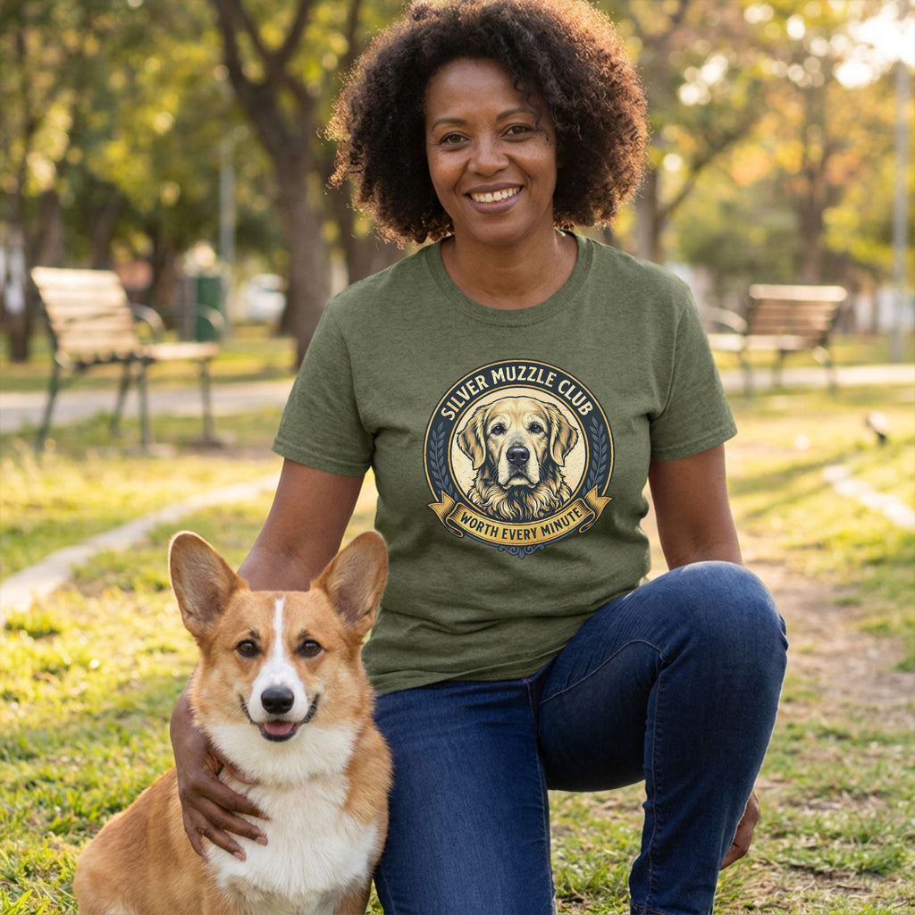 Woman in an olive green "Silver Muzzle Club" tee with a Golden Retriever graphic, kneeling with a Corgi.