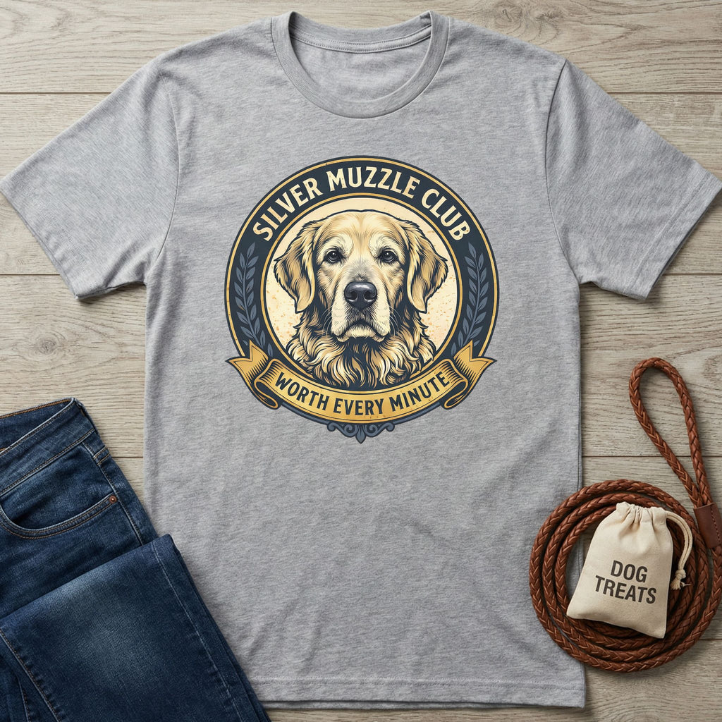 Light grey Silver Muzzle Club t-shirt with a Golden Retriever graphic, next to blue jeans and dog treats.