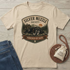 Beige "Silver Muzzle Society" t-shirt with a sleeping senior dog graphic, next to jeans and dog treats.