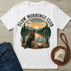 White crewneck t-shirt featuring a dog and coffee mug by a lake with a Slow Mornings Club graphic print.