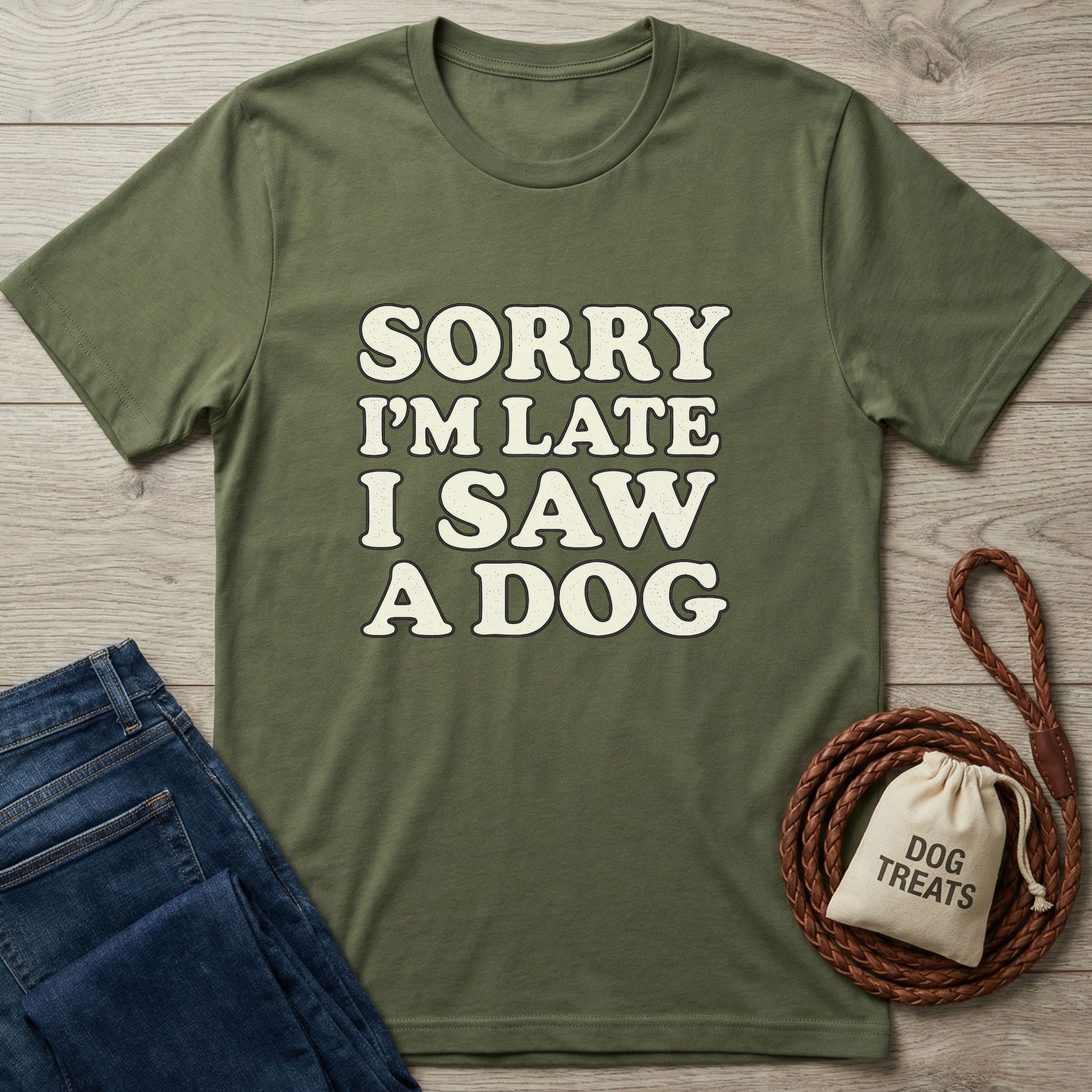 Olive green "Sorry I'm Late I Saw A Dog" t-shirt with jeans, a coiled leash, and a dog treats bag.