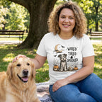 Woman wearing a white cotton t-shirt with a graphic of a wide-eyed dog, pumpkins, and the text Wired Tired Spooked.