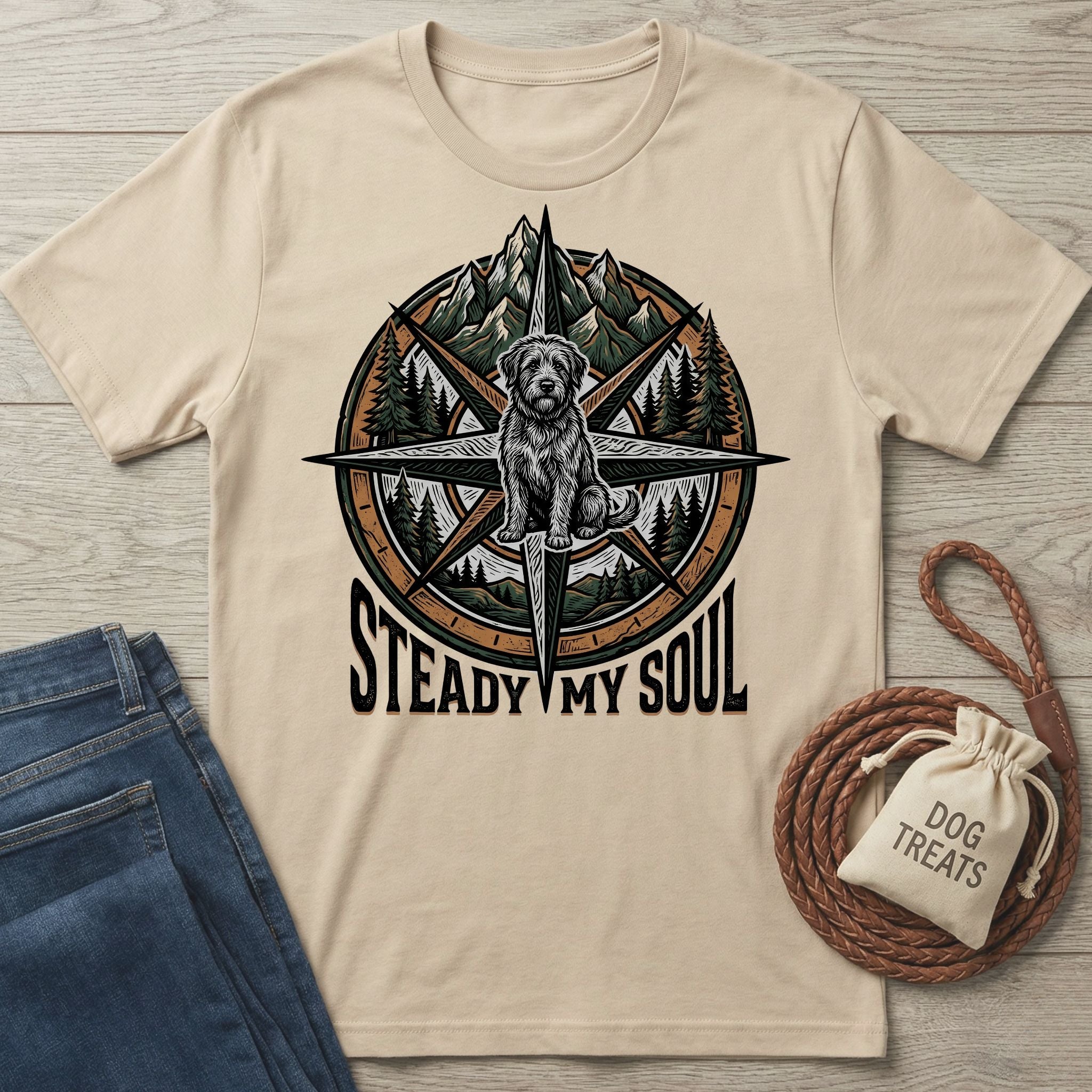 Beige Gildan Softstyle t-shirt with a compass, mountains, trees, a rescue dog, and "Steady My Soul" graphic.
