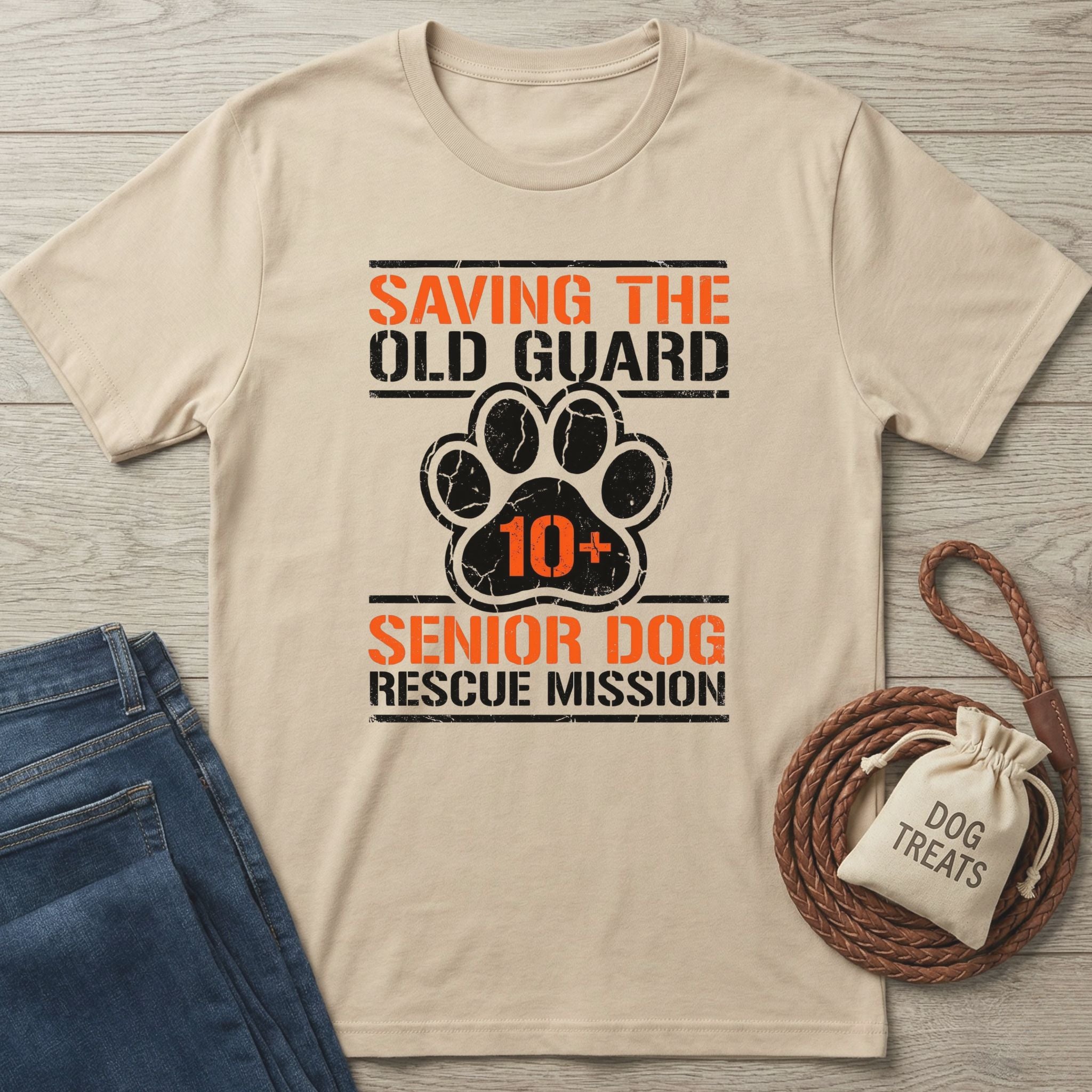 Tan Gildan Softstyle® t-shirt with "Saving The Old Guard Senior Dog Rescue Mission" text and paw print design.