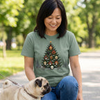 Woman wearing a sage green crewneck T-shirt featuring a Christmas tree graphic decorated with various dog breed ornaments.