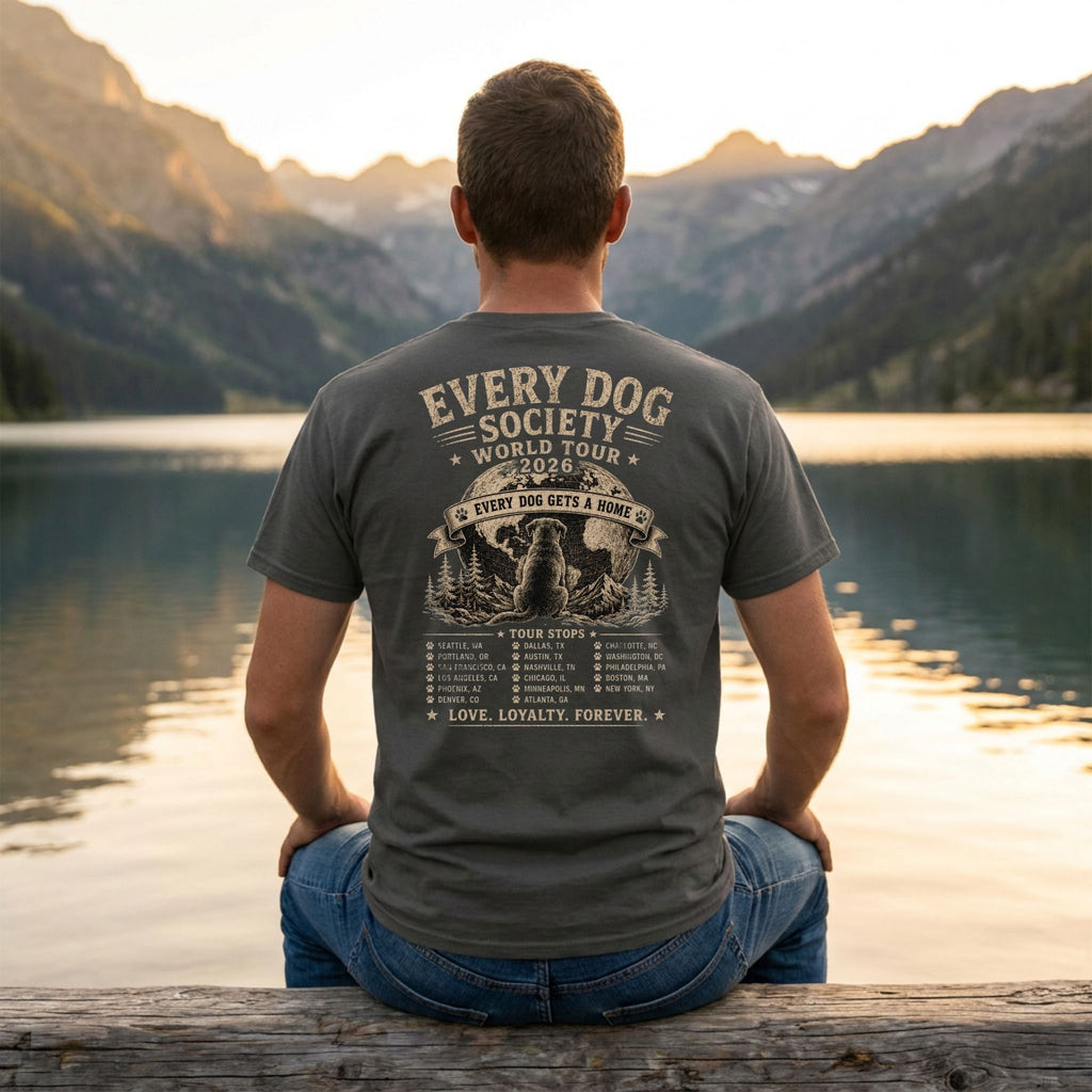 Charcoal grey vintage-style band t-shirt with a dog-themed world tour graphic on the back, worn by a man at a lake.